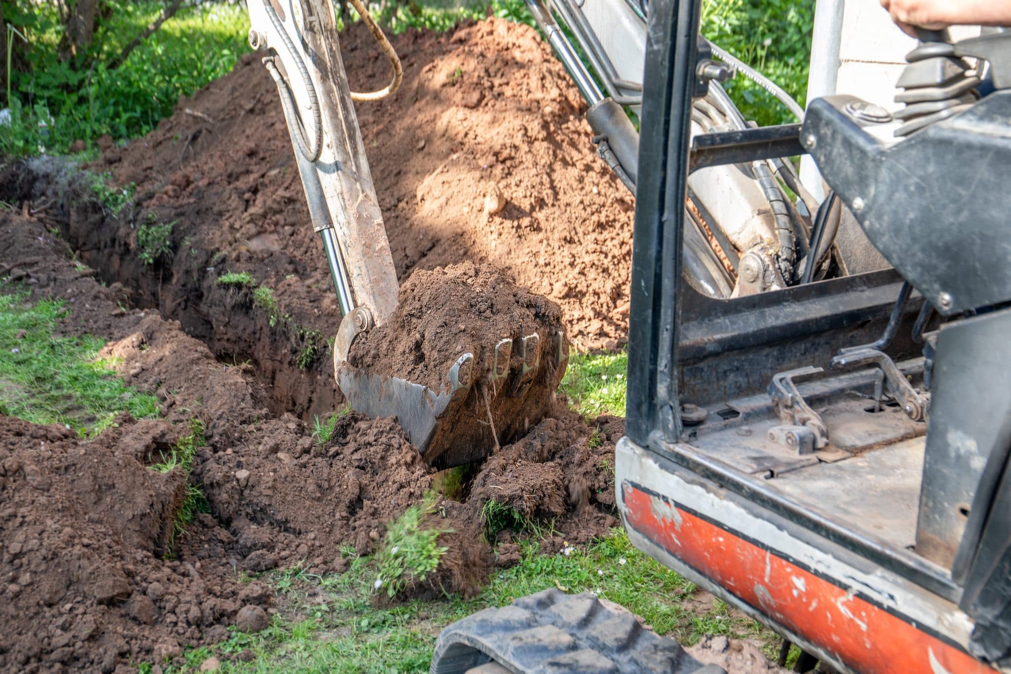 Excavation equipment working on an underground utility trench