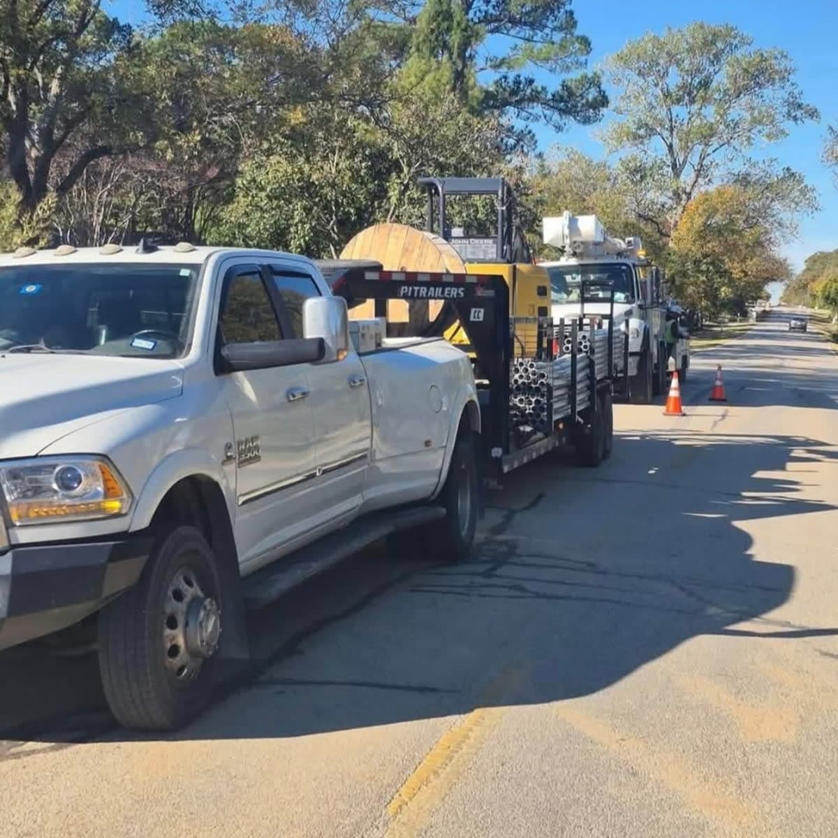 Cable reel and field vehicles staged for cable pulling work.