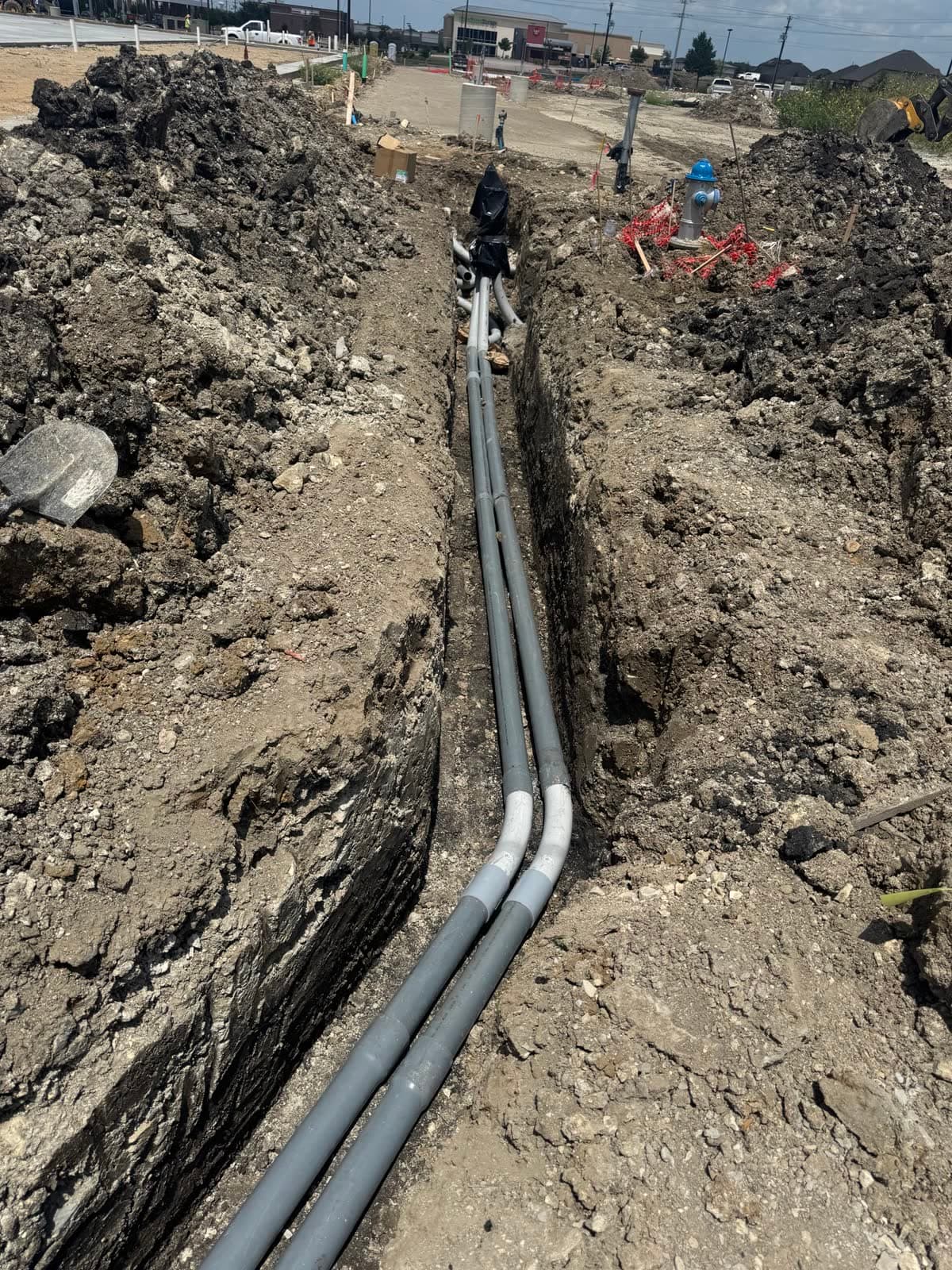 Underground conduit installed at a commercial project site.